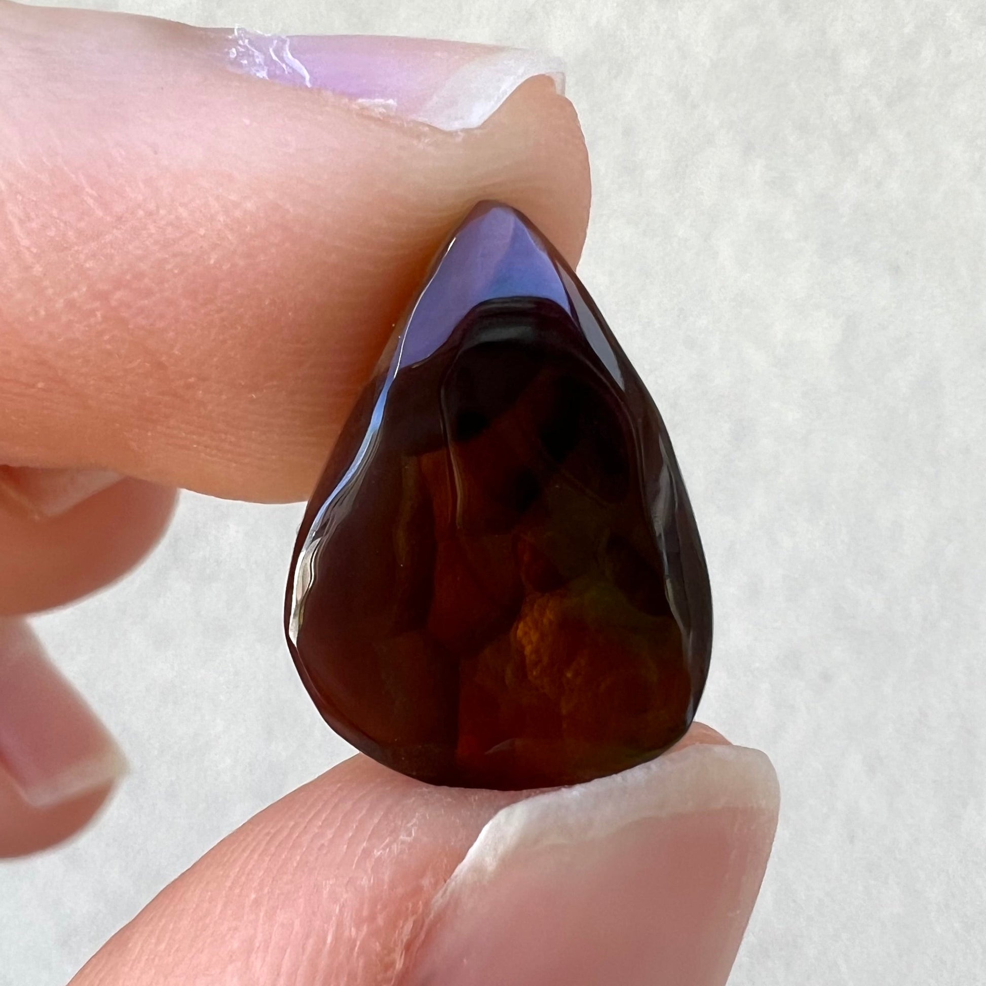 A loose, pear shaped Mexican fire agate gemstone.  The stone is predominantly vivid red with green overtones.