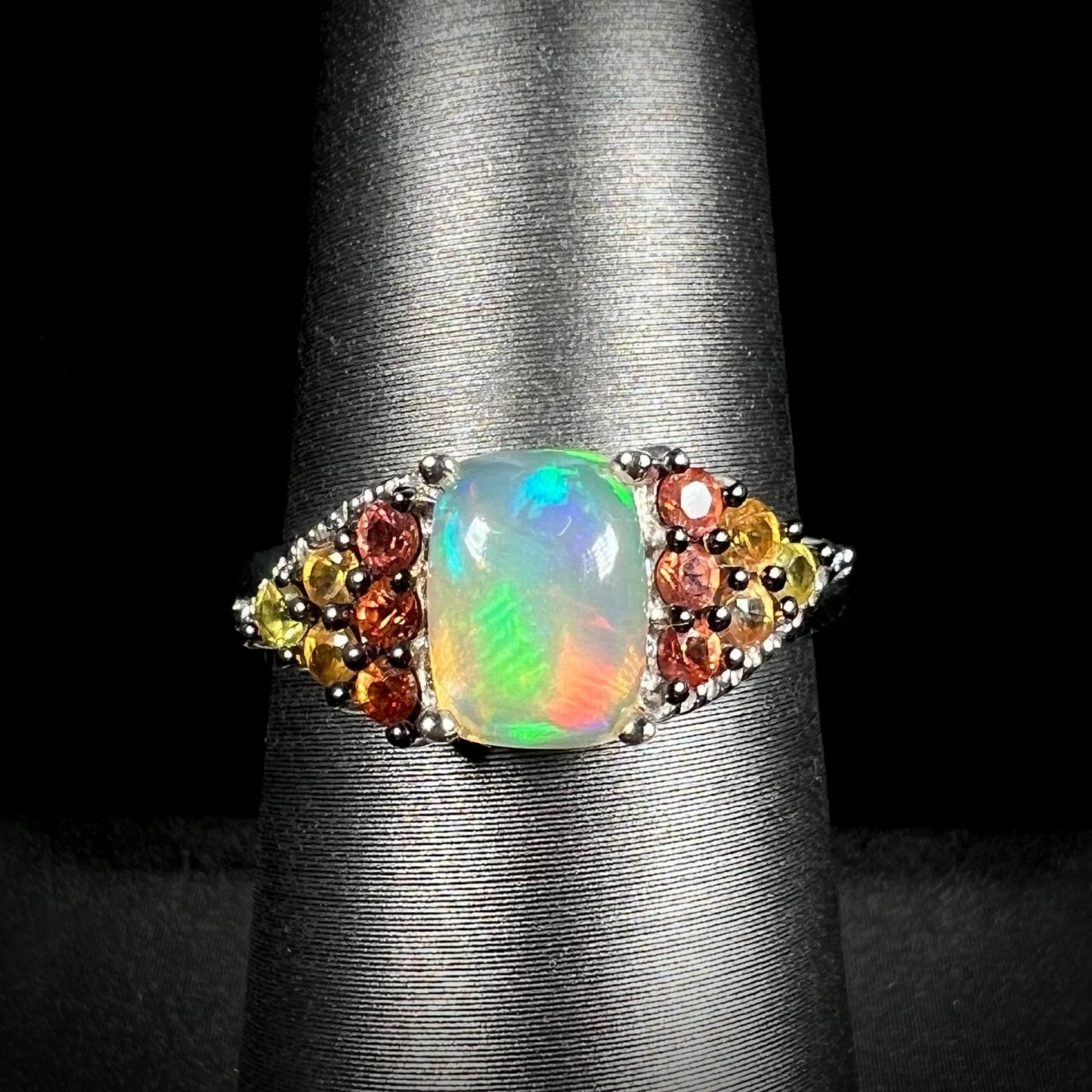 A ladies' silver ring set with a cushion cabochon cut Ethiopian fire opal stone and citrine accents.
