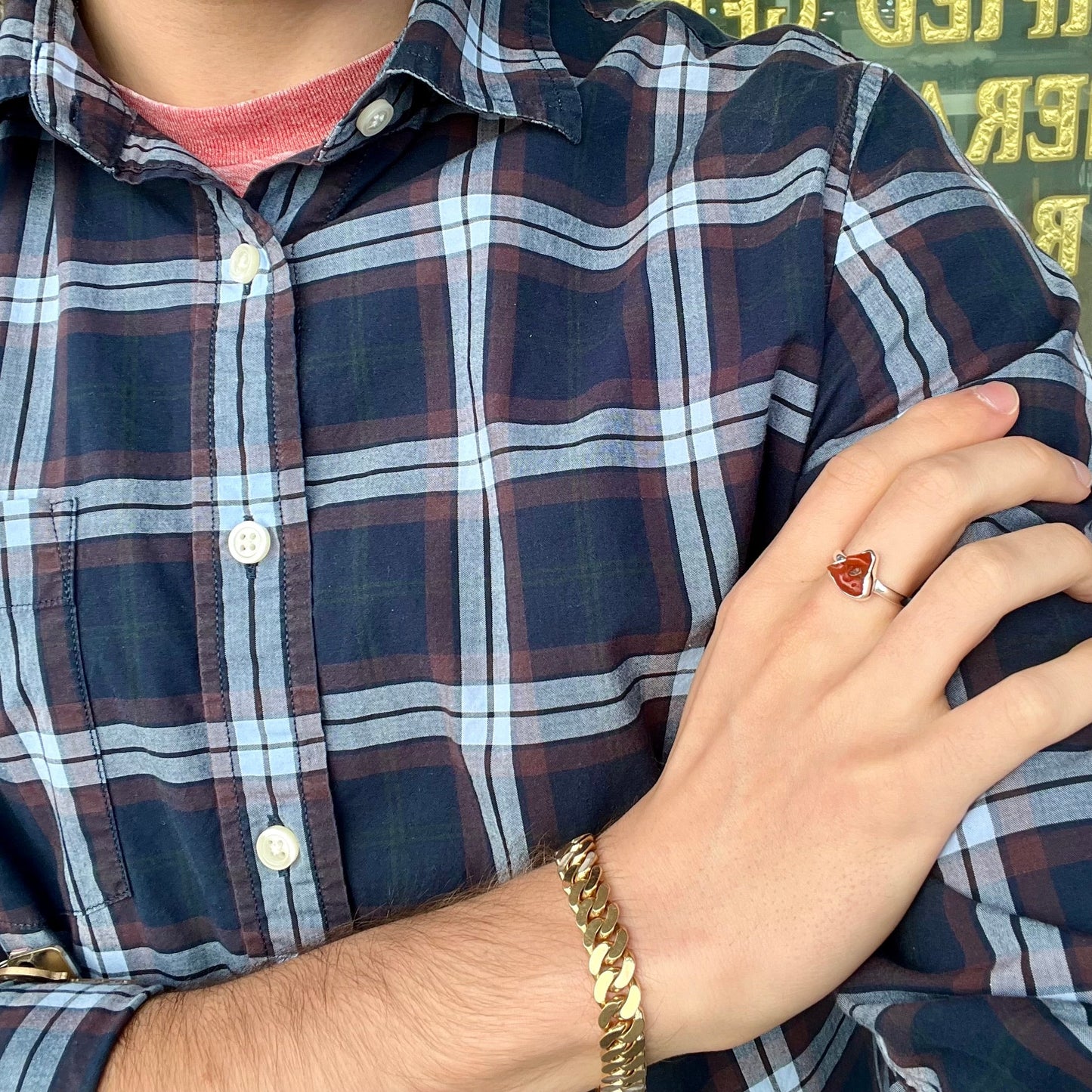 A polished fire opal crystal bezel set into a sterling silver ring. The opal is an orange color.