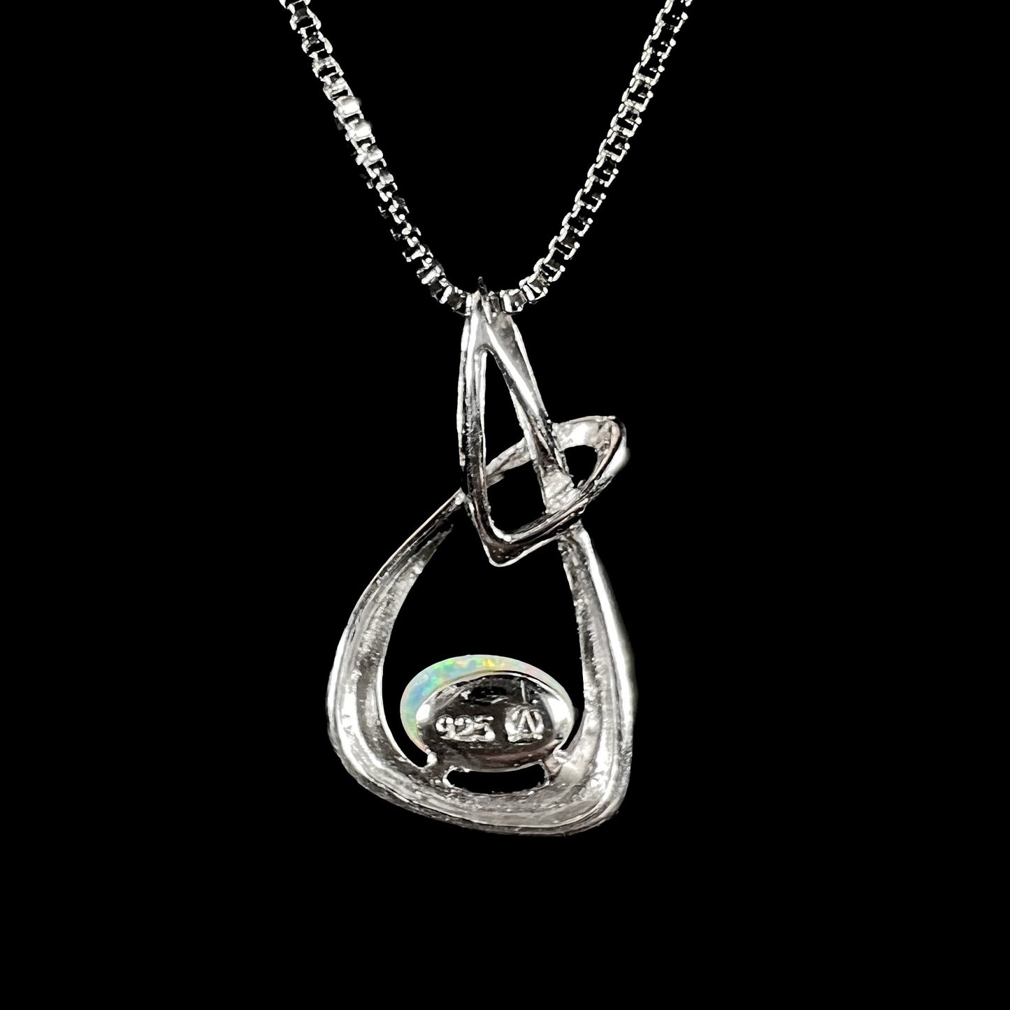 A ladies' sterling silver pendant set with an oval cabochon cut natural white crystal opal.