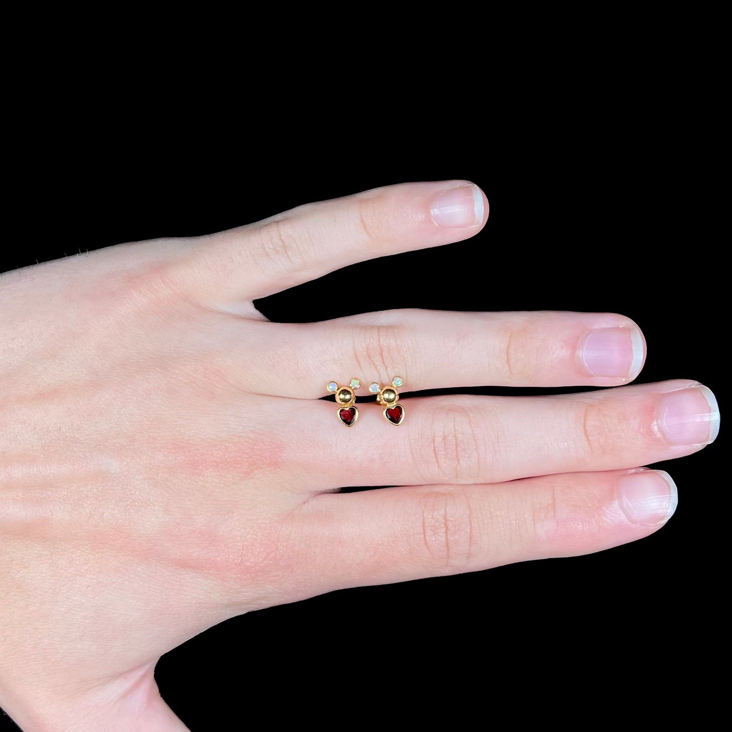 A pair of 18 karat yellow gold stud earrings set with two round fire opals and heart shaped garnets.
