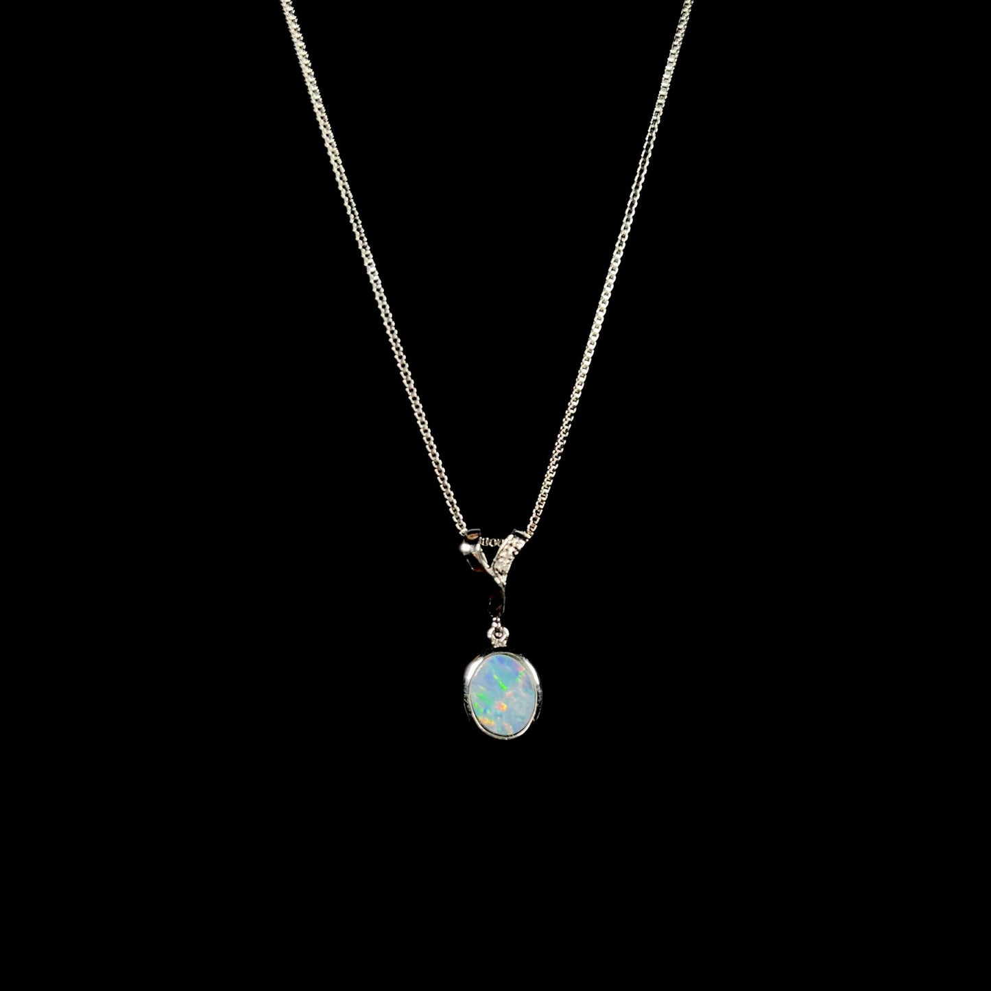 A sterling silver necklace set with a natural black opal doublet and white zircon accent stones.