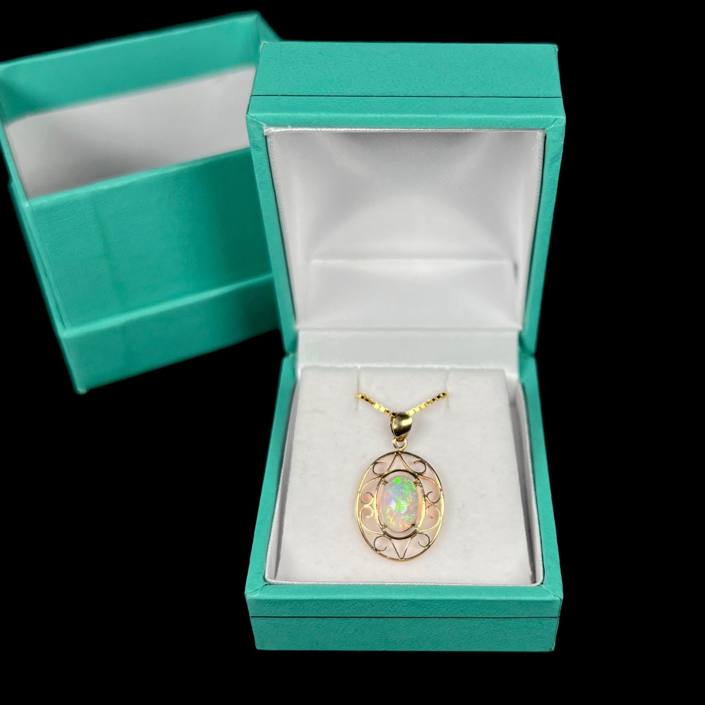 An 18 karat yellow gold filigree opal necklace. The opal has bright green color play.