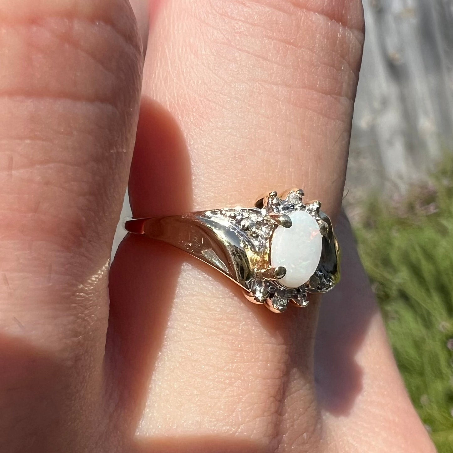 A ladies' contemporary-style gold ring mounted with a white opal and diamond accents.