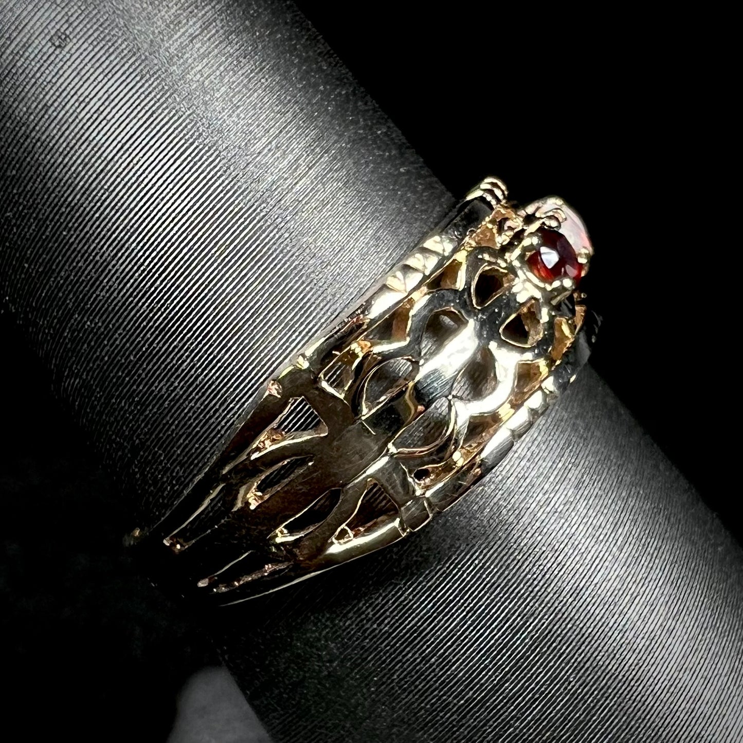 Side view of a gold band with an open, woven design.