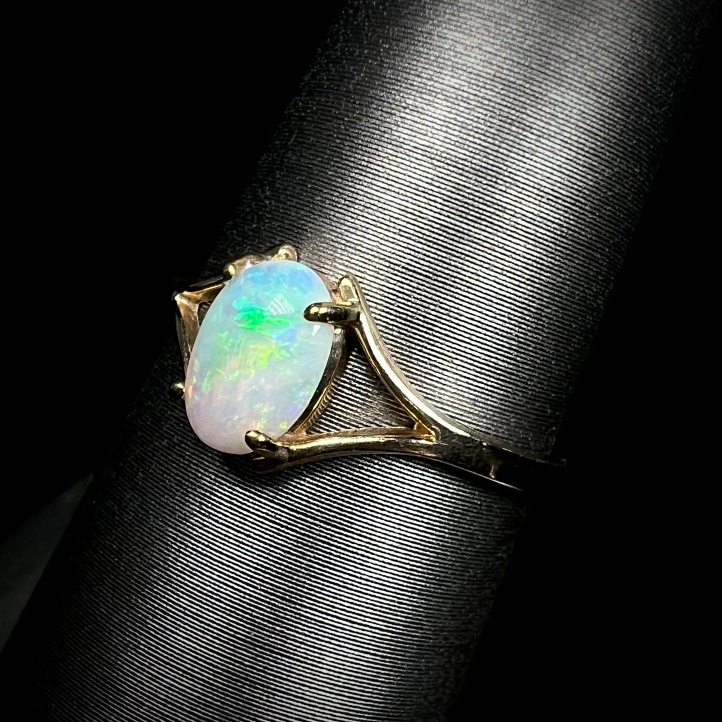 A ladies' simple opal solitaire ring. The ring is yellow gold with a split shank.