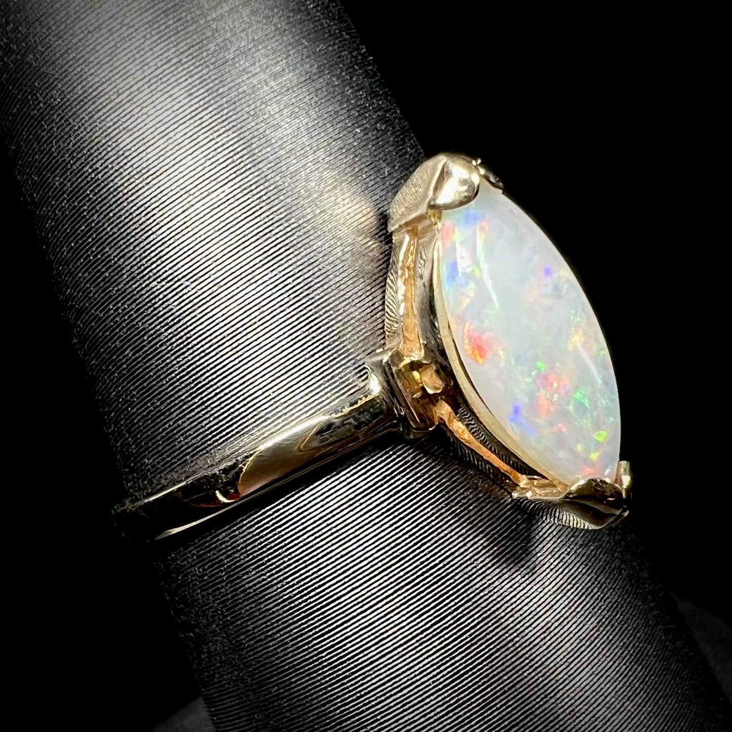 A marquise cut natural opal solitaire ring in yellow gold.