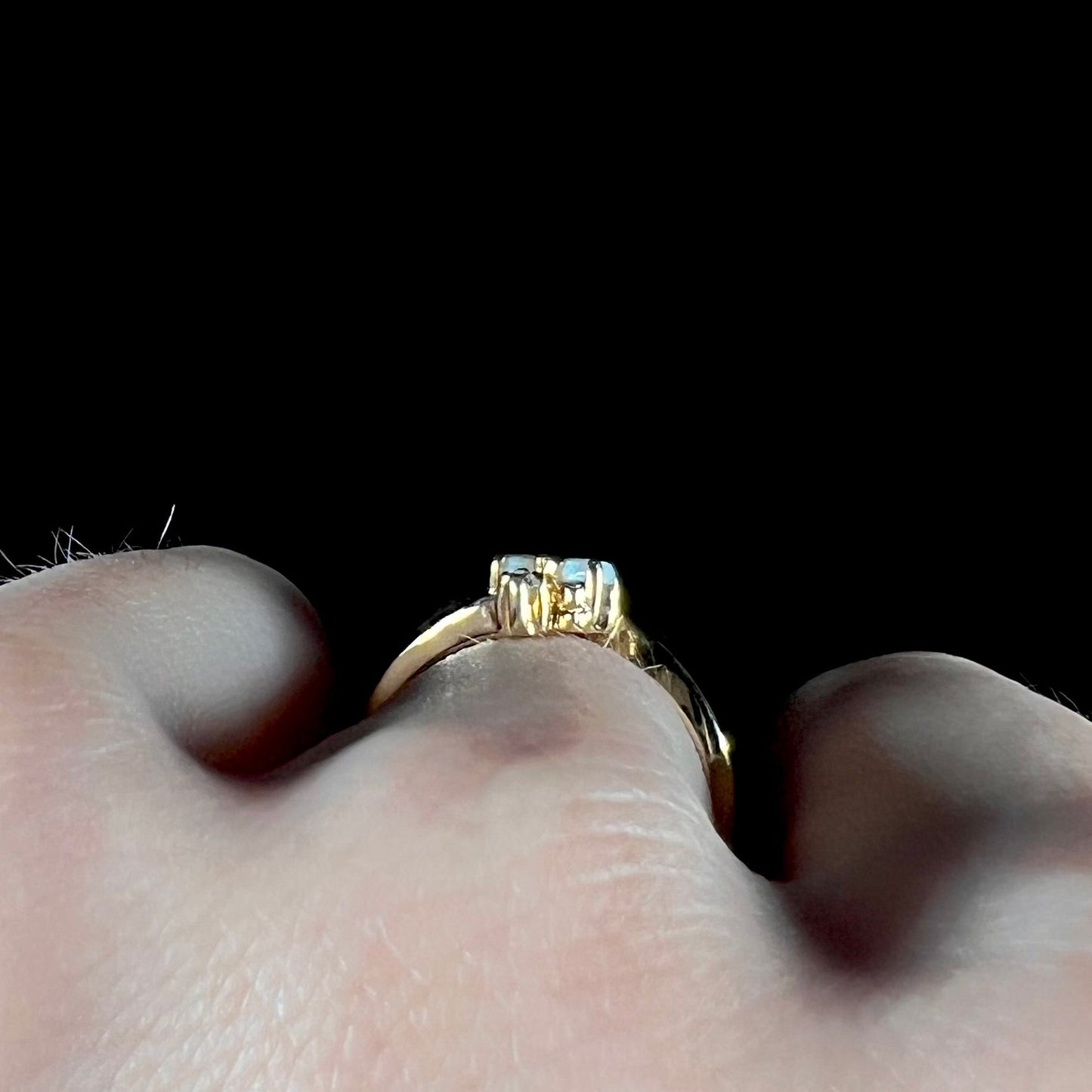 A ladies' gold ring mounted with two marquise cut opals and two diamond accents.