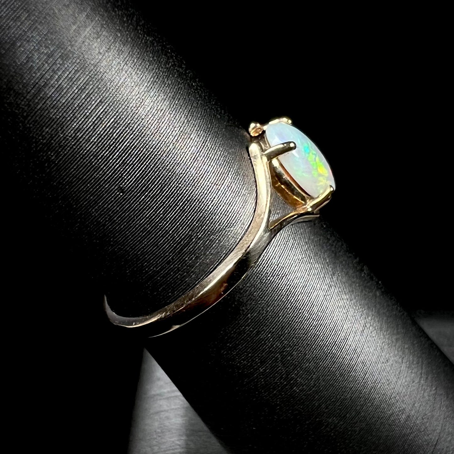 A ladies' simple opal solitaire ring. The ring is yellow gold with a split shank.