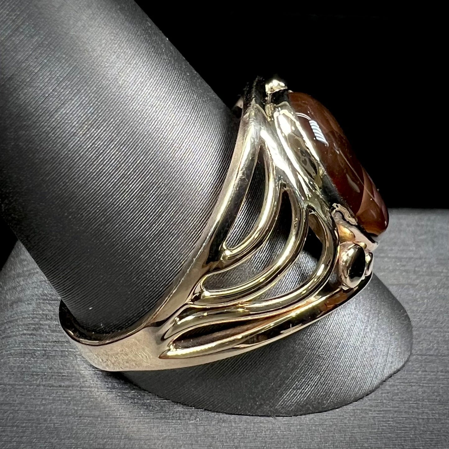 A men's yellow gold fire agate ring. The fire agate is blue and purple with light scratches.