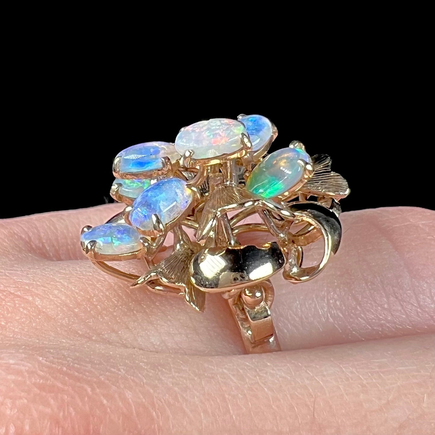 A ladies' vintage, modernist style opal cluster ring in yellow gold. The ring is tall with a high profile.