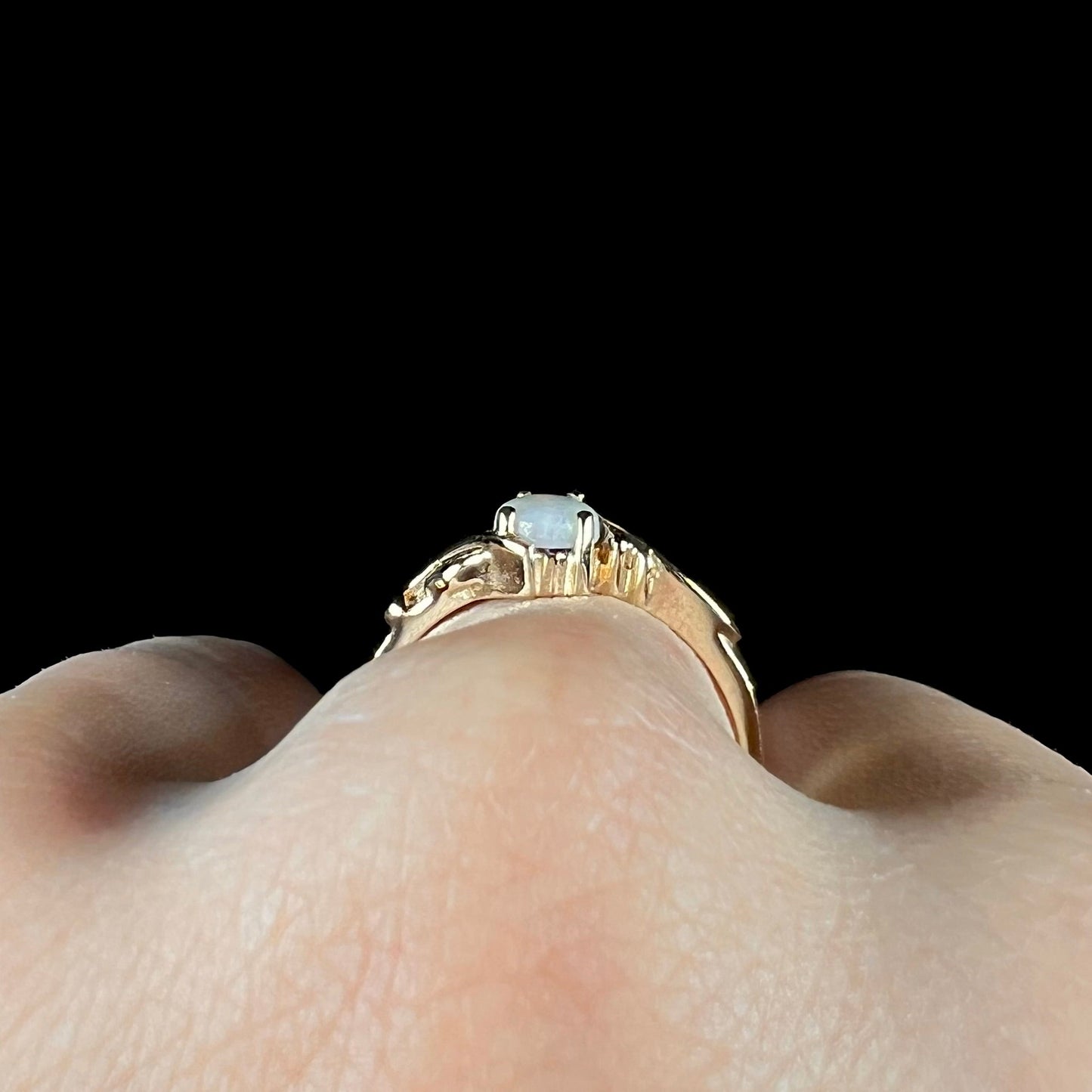 A ladies' two-tone yellow and rose Black Hills gold opal and diamond ring. The opal is a pear shaped cabochon.