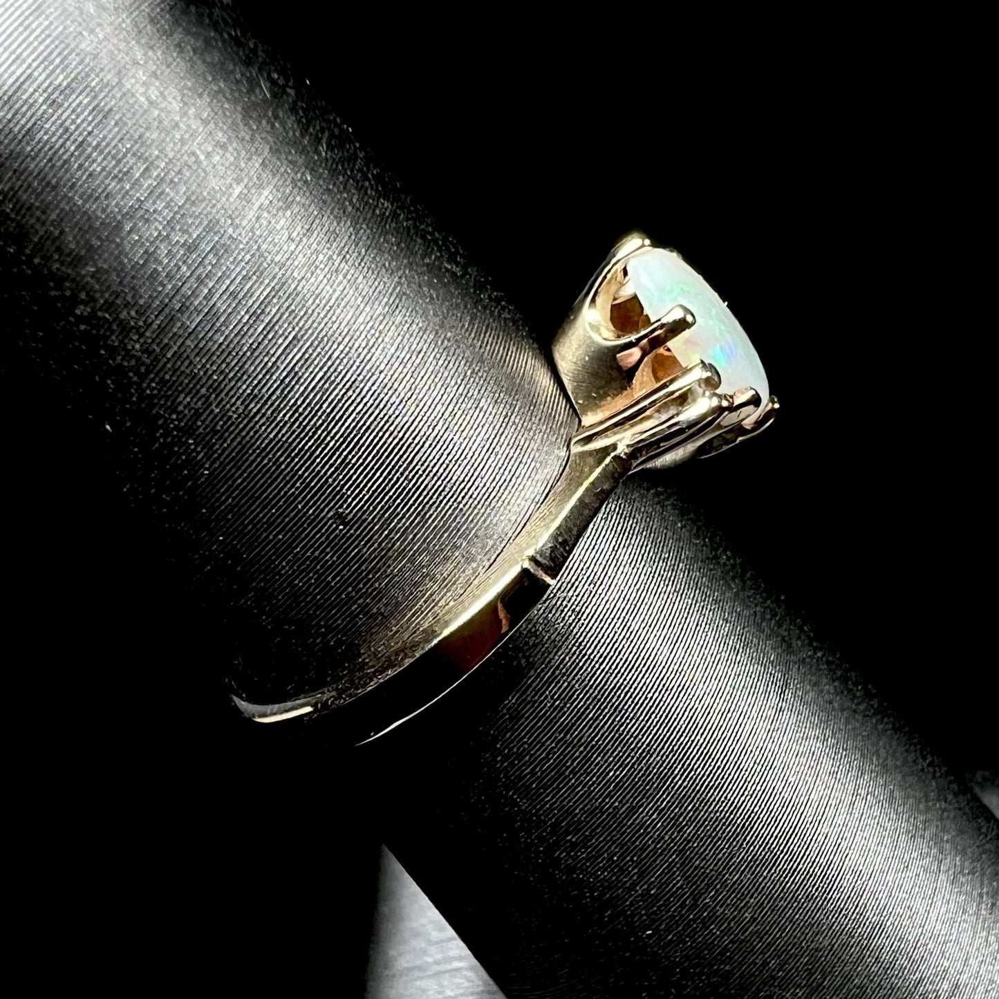 A dainty, 1960's style opal and diamond engagement ring. The ring is prong-set and yellow gold.