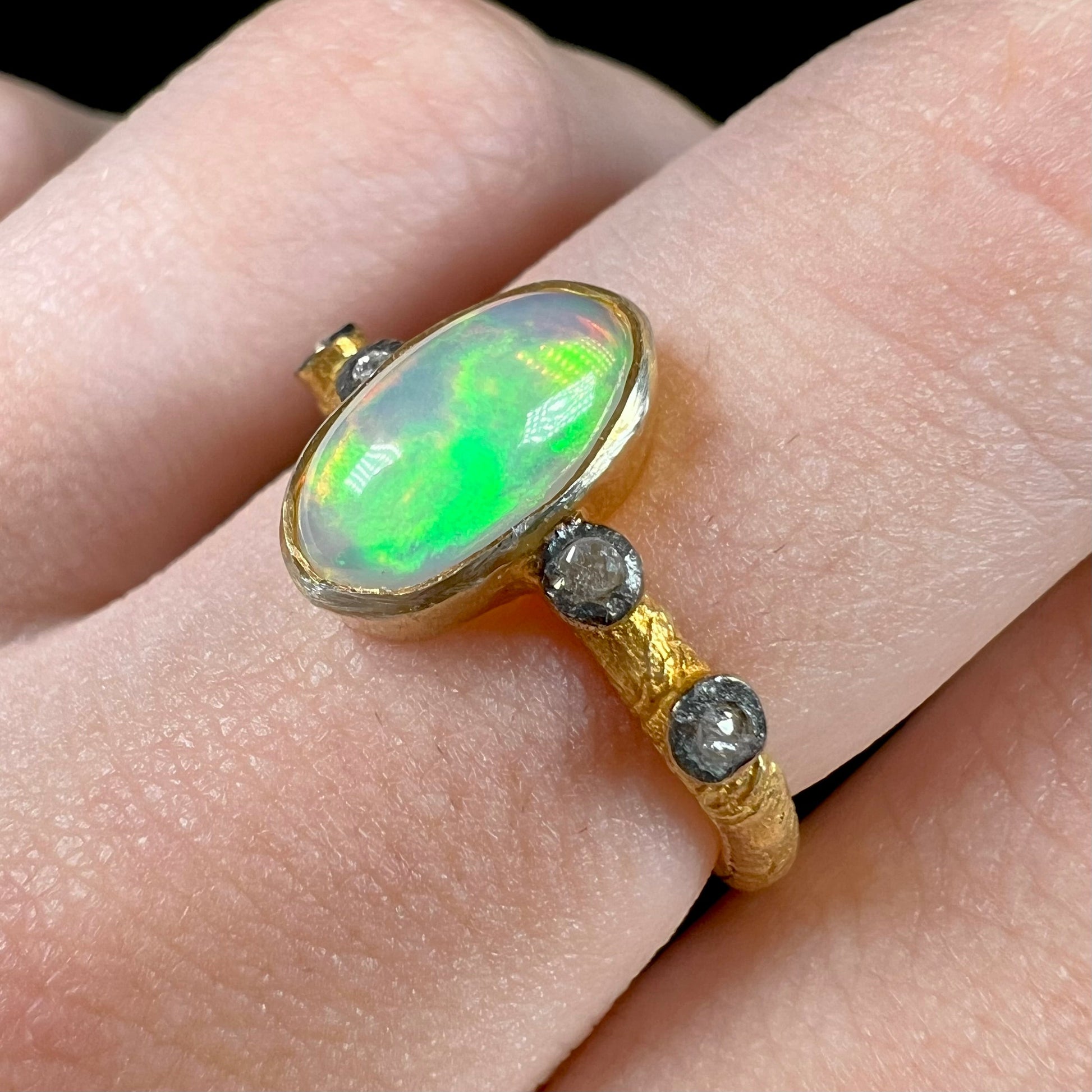 A yellow gold plated sterling silver ring mounted with an Ethiopian fire opal and rose cut diamond accents.