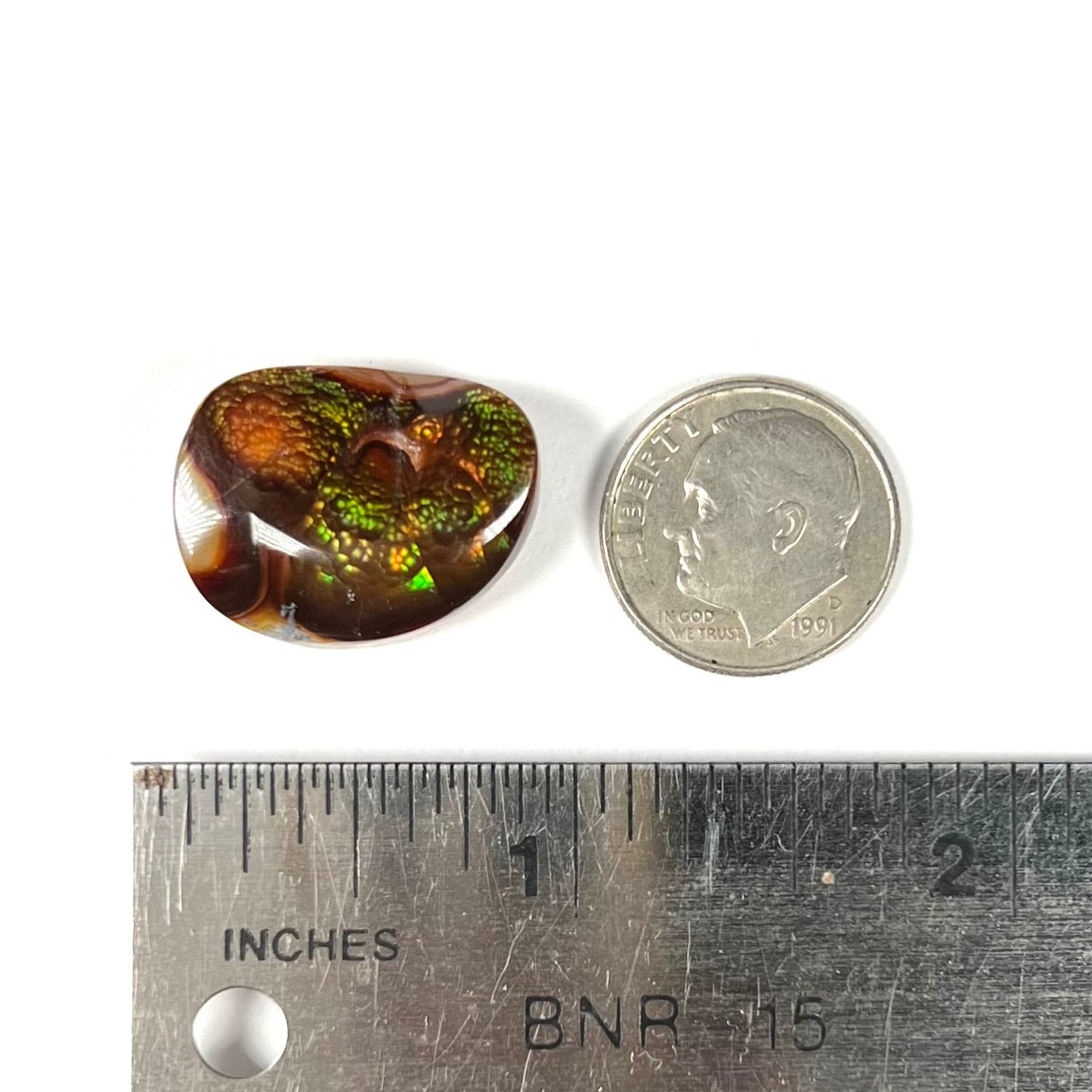 A large Mexican fire agate cabochon. The stone has a bubbly green pattern.