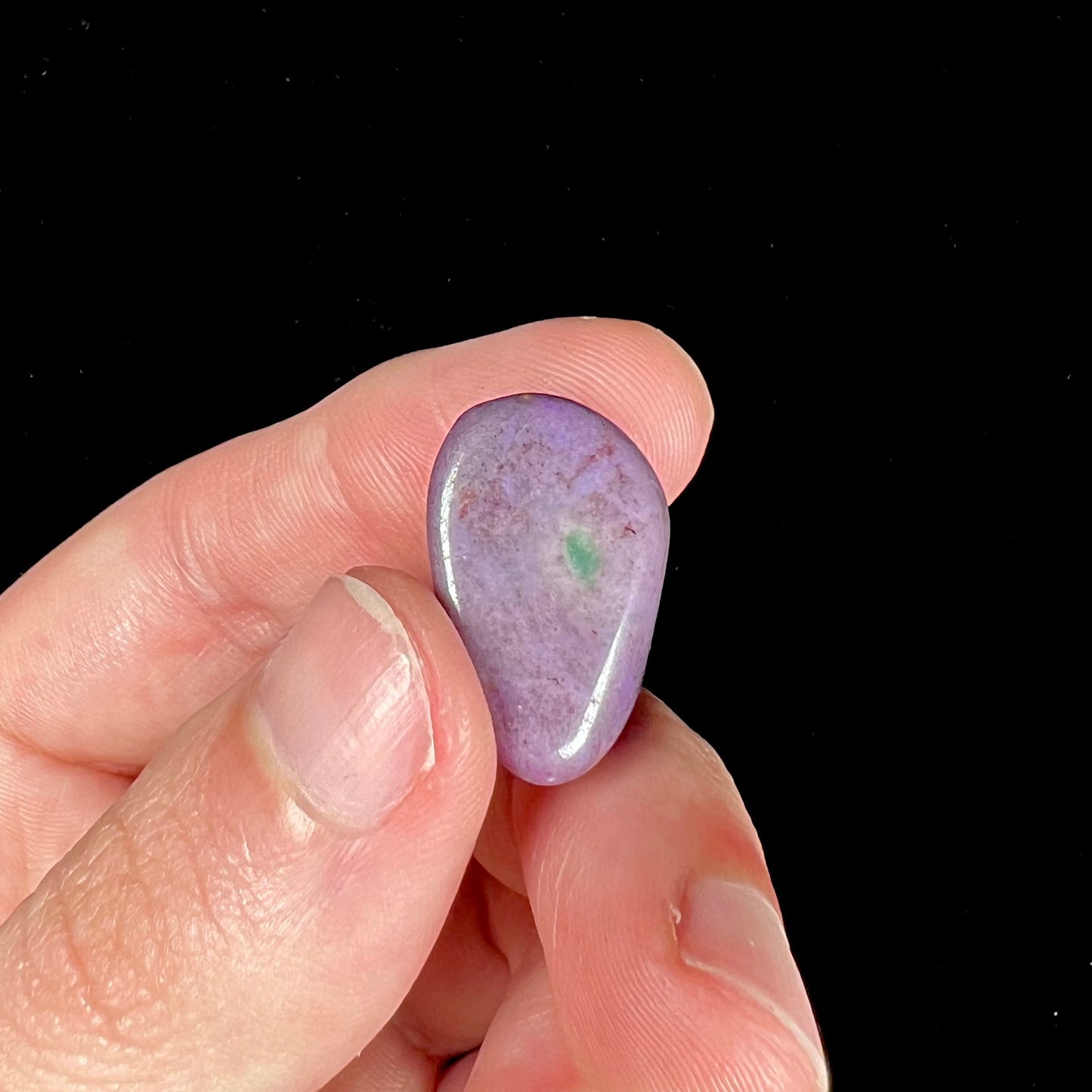 A tumbled purple turkiyenite jade stone from Borsa, Turkey. The stone has a green jadeite inclusion.