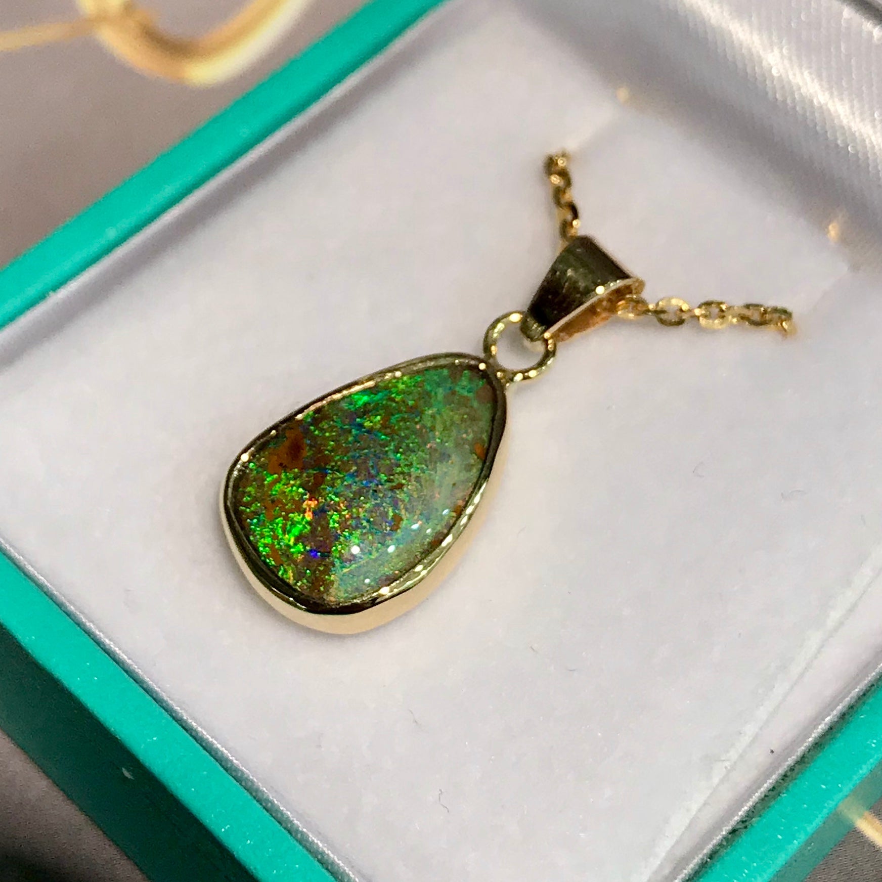Green and blue Queensland boulder opal pendant in 14k yellow gold on cable chain.
