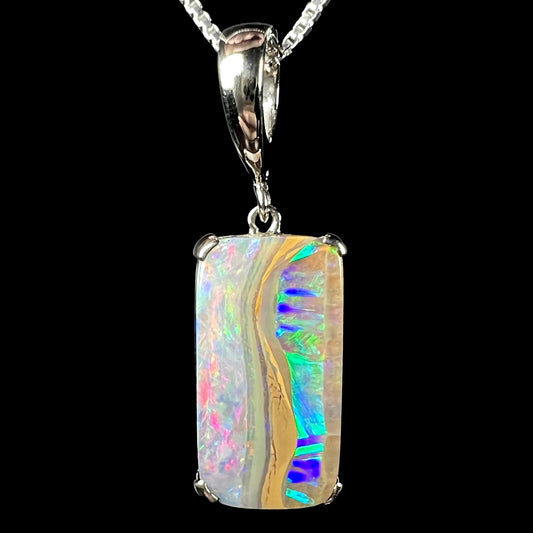 Macro close-up of the Hakumei Australian boulder opal pendant against a black background, showcasing vibrant blue, green, and pink color play.