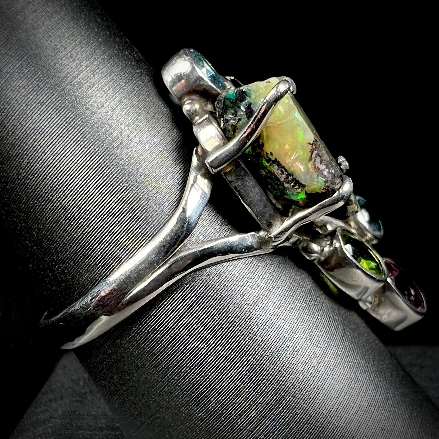Side view of a handmade silver men's ring set with a rough Virgin Valley opal stone.