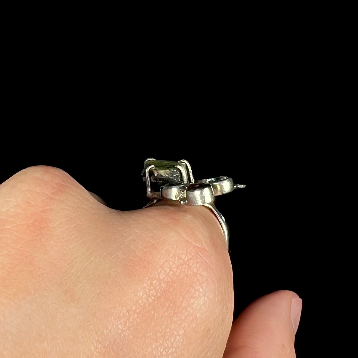 A handmade silver rough opal ring shown from the side profile, worn on a hand.