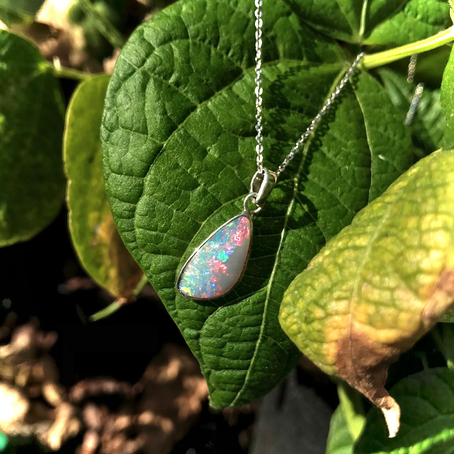 A handmade Lightning Ridge white crystal opal pendant on a sterling silver cable chain.