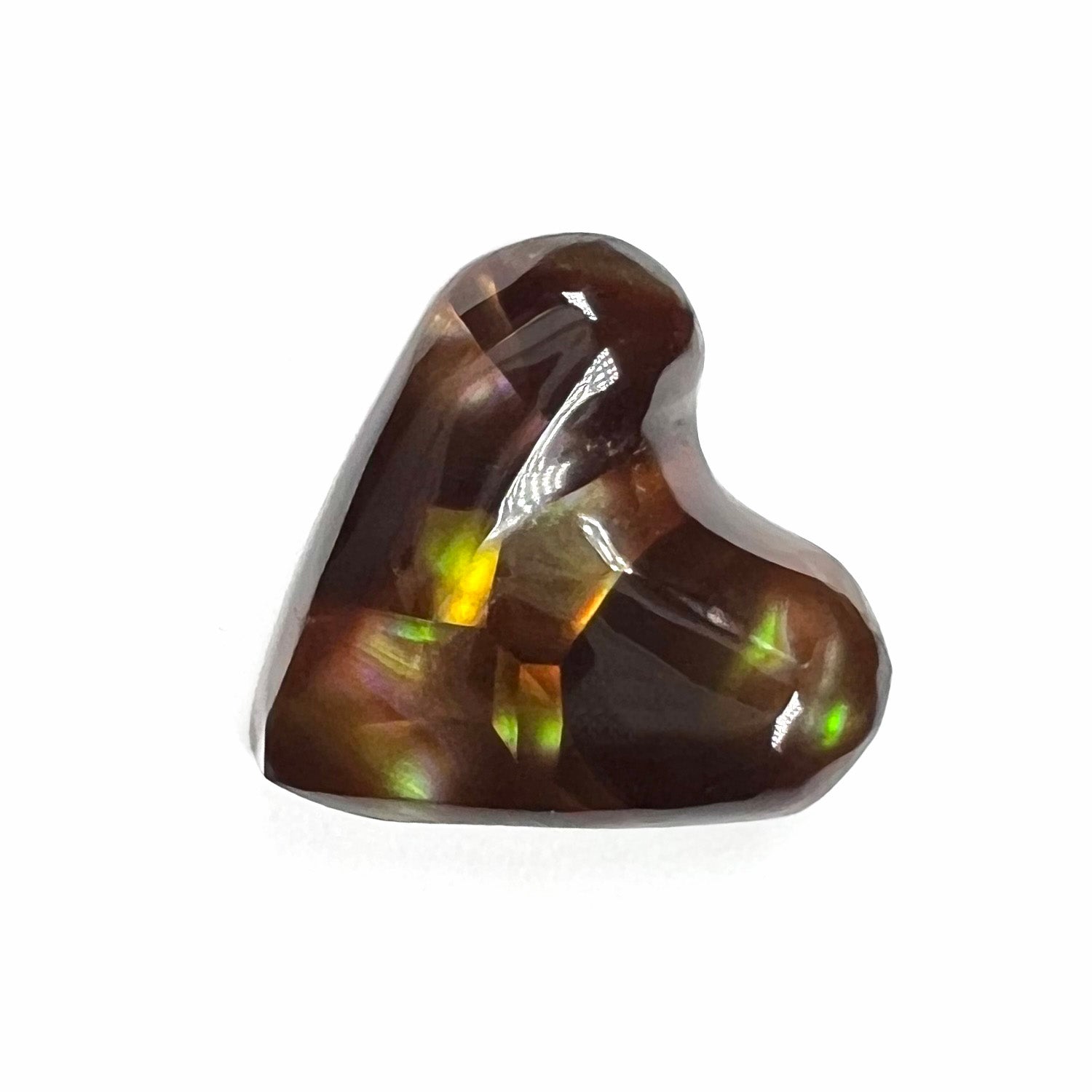 A cabochon cut heart shaped Mexican fire agate stone.  The stone is orange, yellow, pink, green, and purple.