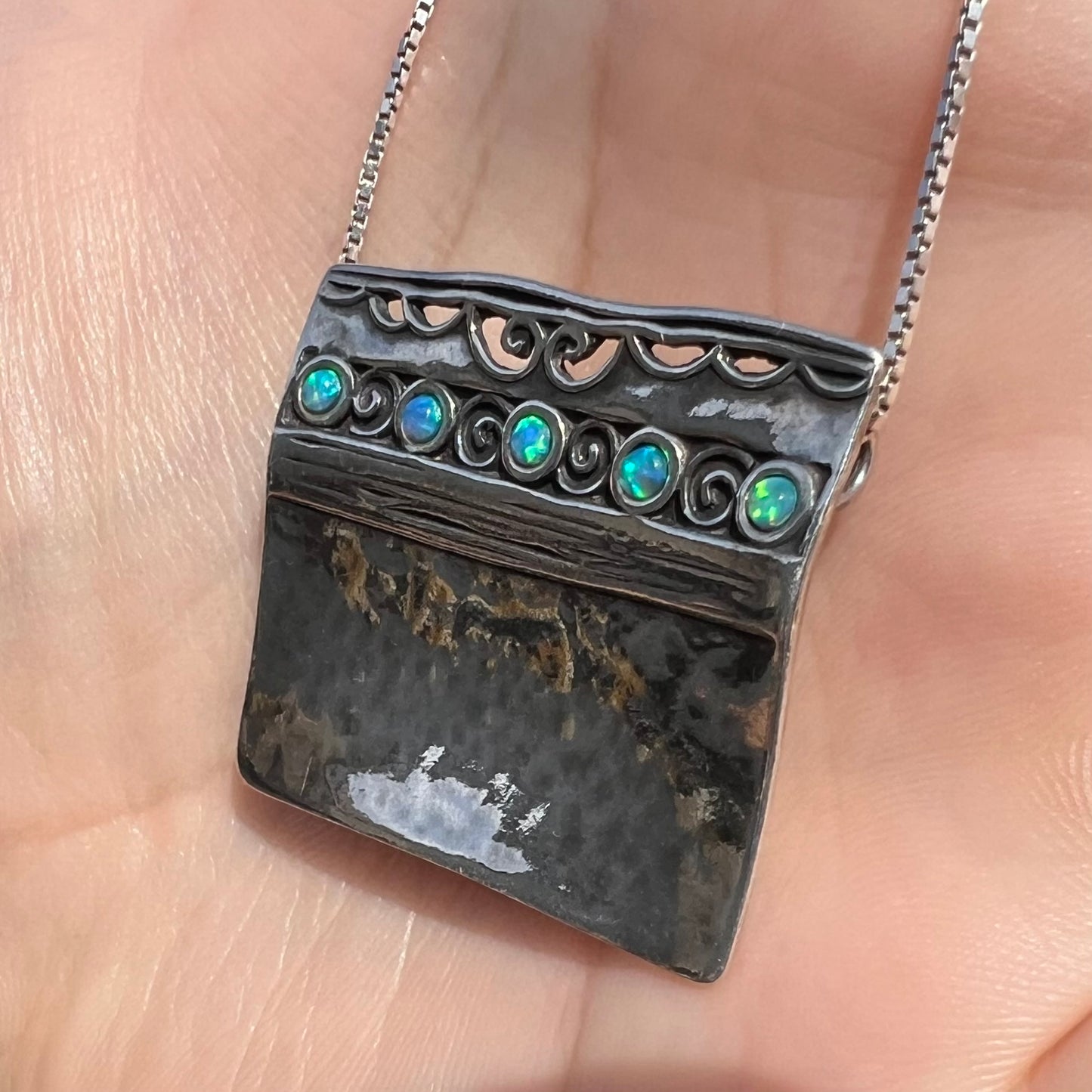 A handmade sterling silver five-stone opal necklace with a hammered finish by Israeli designer, Shablool Didae.