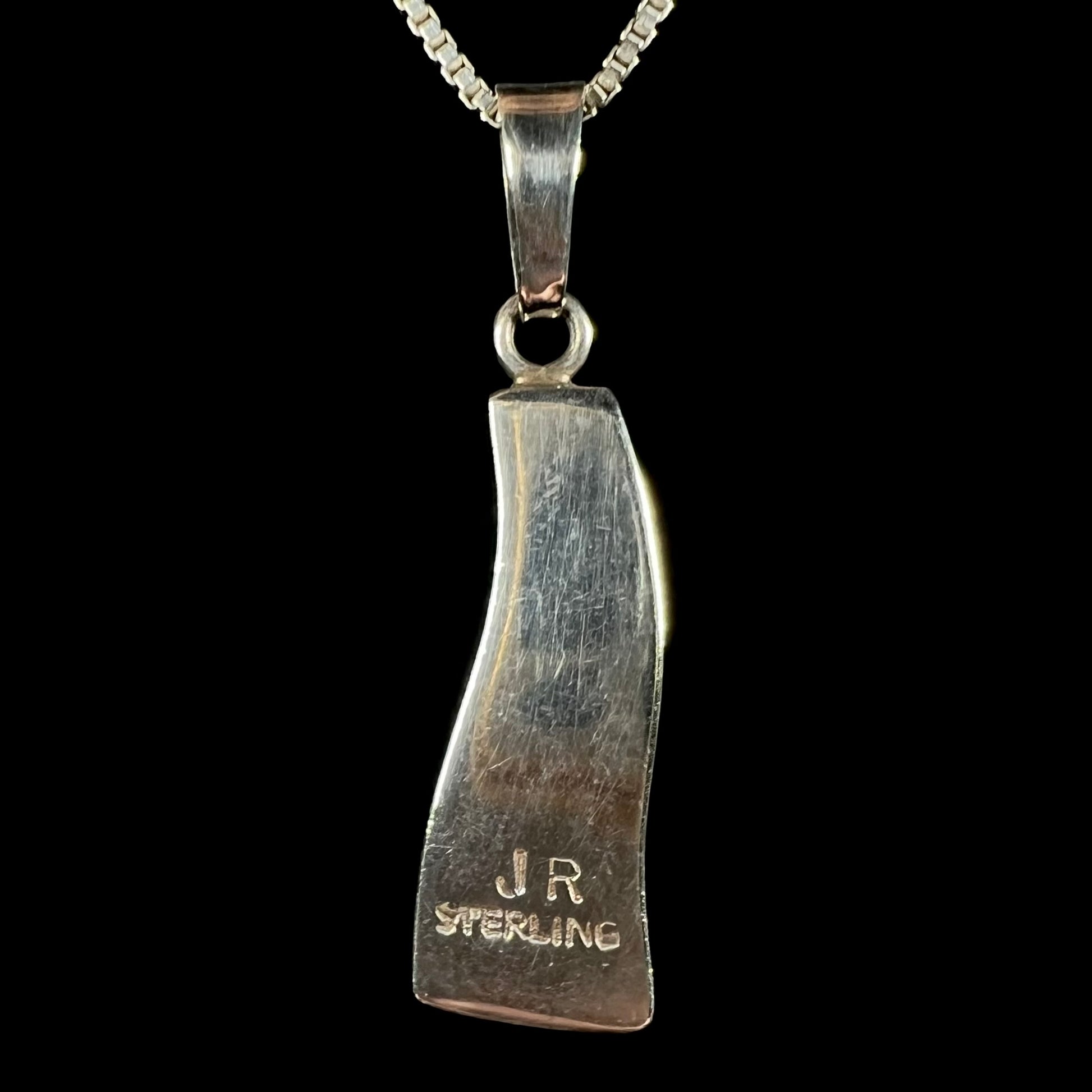 Back side of a sterling silver pendant signed "JR" and "STERLING" by Navajo artist, Johnson Ralph.