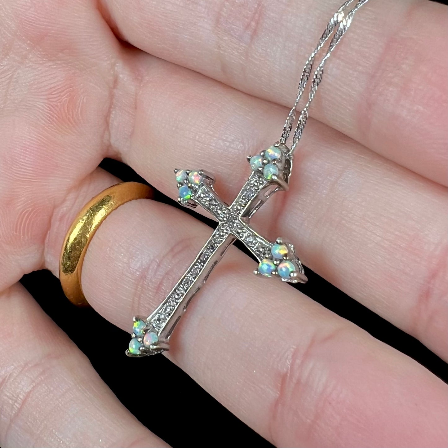 A sterling silver lab-created opal cross necklace with CZ accents.
