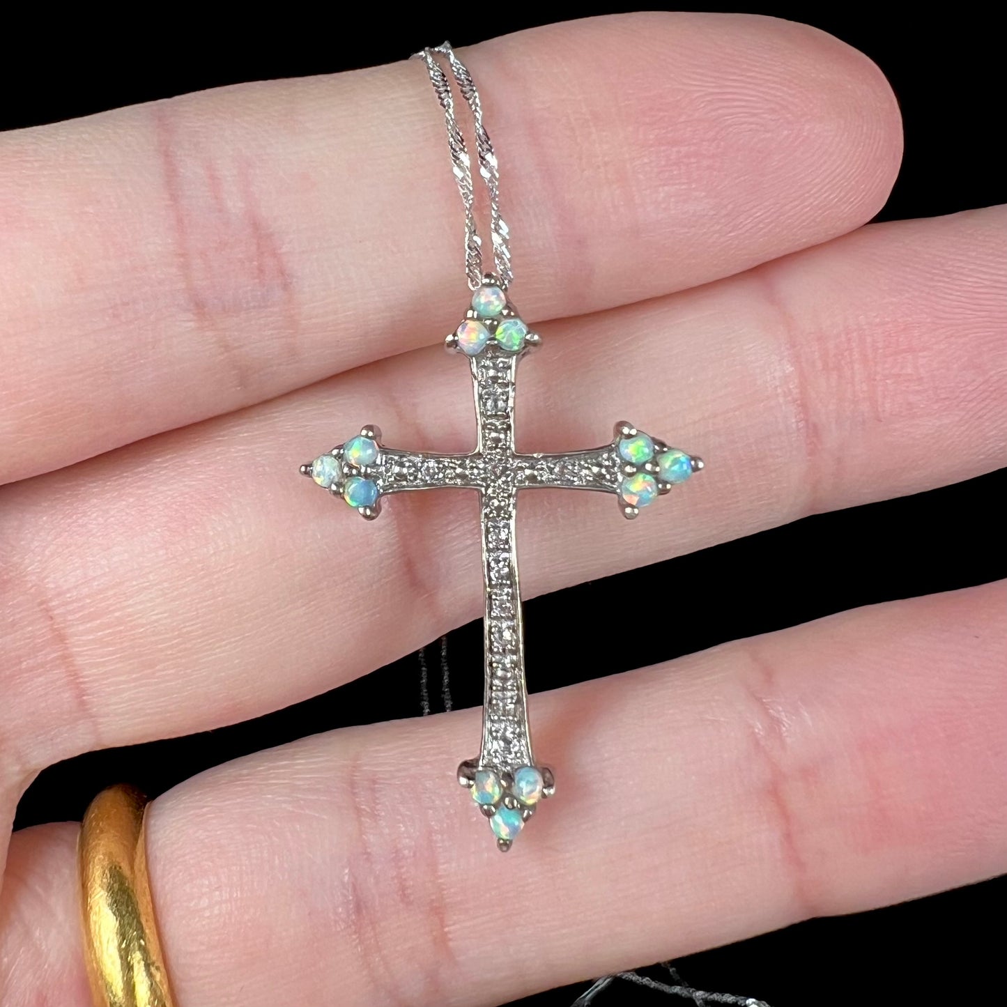 A sterling silver lab-created opal cross necklace with CZ accents.