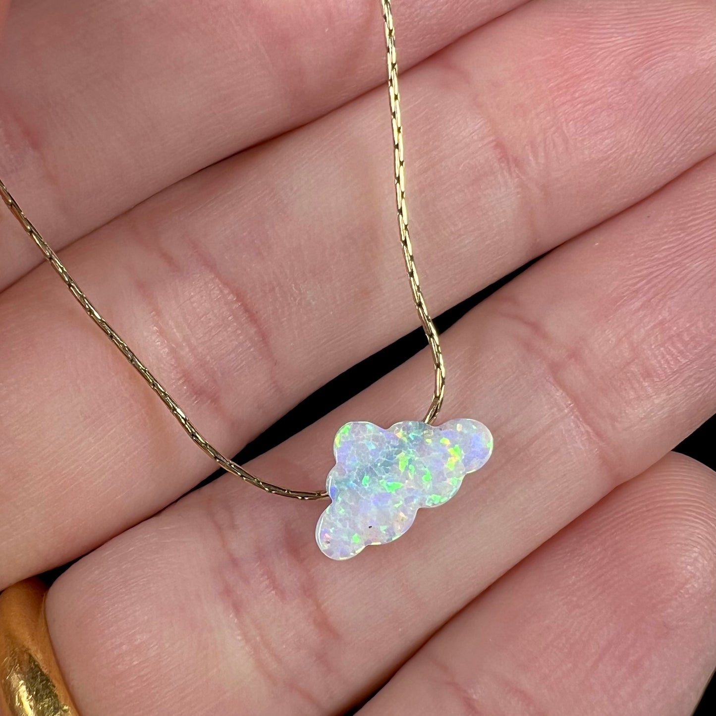A lab-created opal cloud necklace on a gold filled chain.