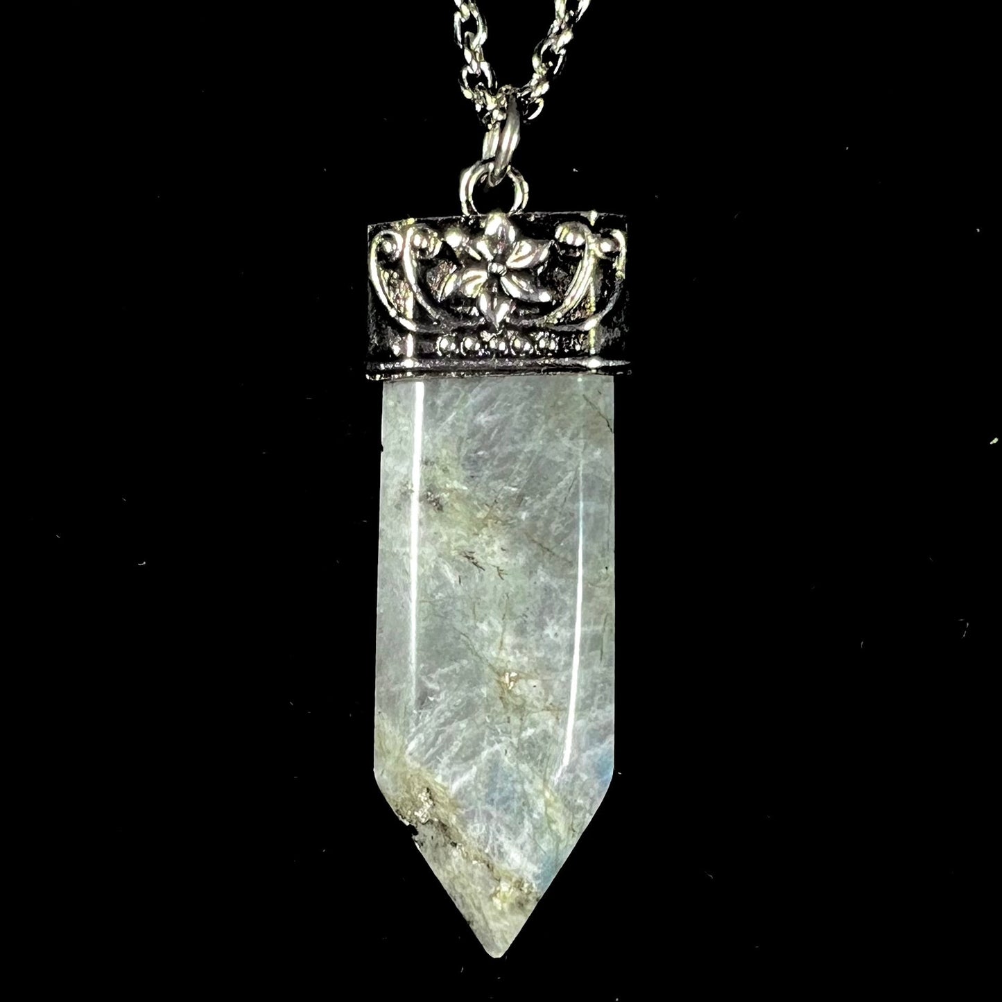 A stainless steal necklace set with a crystal shaped labradorite stone, purple glass, and an opalite accent.