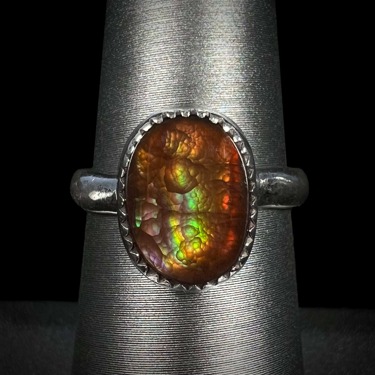 A ladies' sterling silver fire agate solitaire ring with green color, shown from the front view.