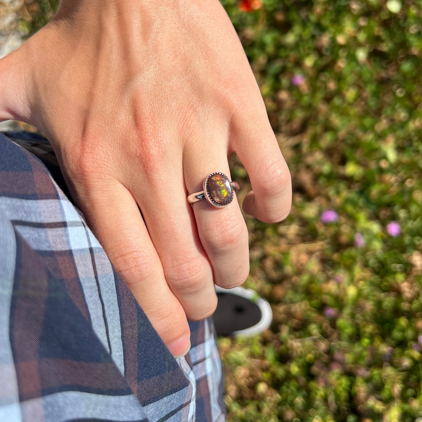 Person resting hand on their hip, wearing a ladies' fire agate ring in natural light.