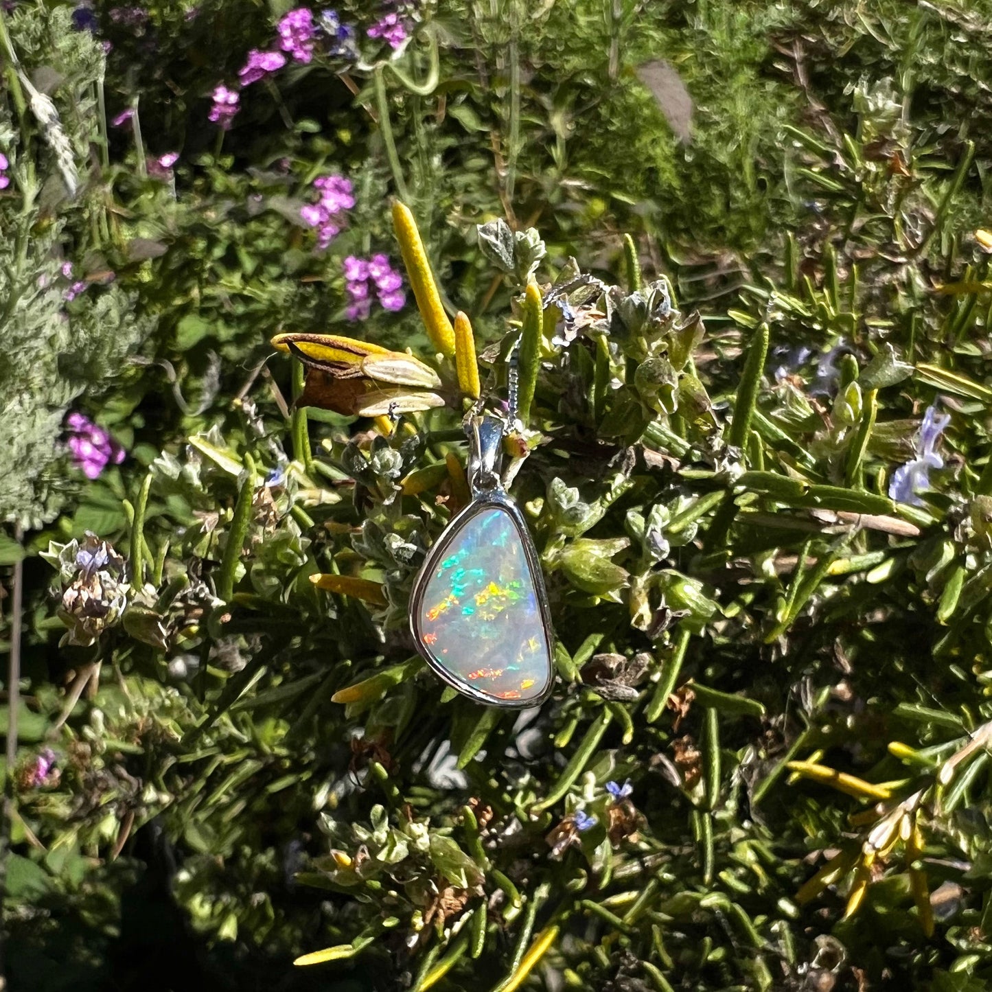 A sterling silver pendant bezel set with a white Australian crystal opal on a box chain.