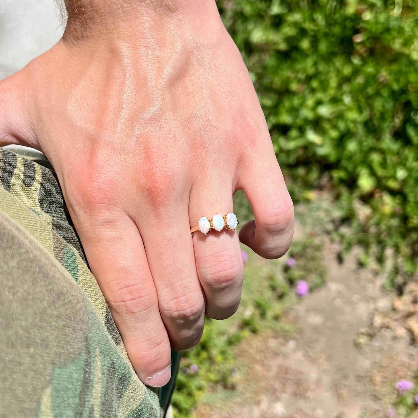 A vintage yellow gold ring mounted with three oval cut white Australian opals.