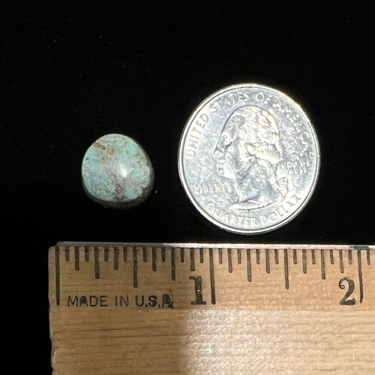 A loose, off-round cabochon cut turquoise stone. The stone is light blue with a red webbed matrix.