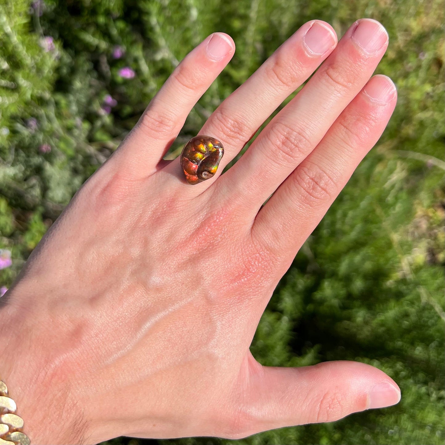 A large Mexican fire agate gemstone. The stone is red with green iridescence and a waxy luster.