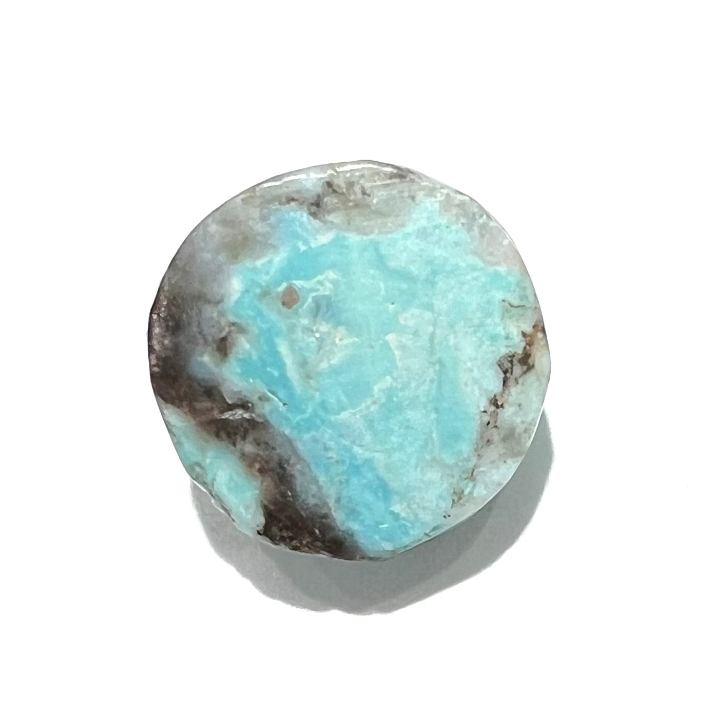 A loose, round cabochon cut Valley Blue turquoise stone.