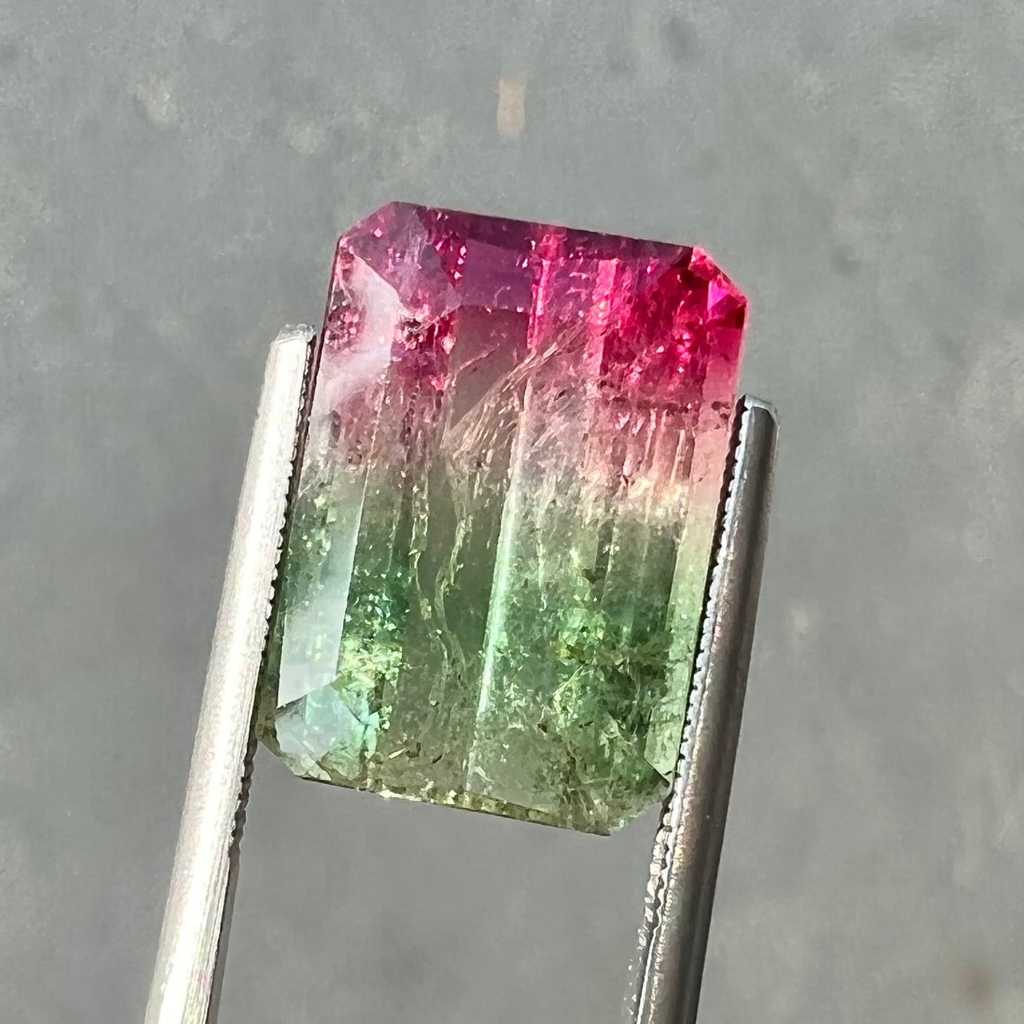 A loose pink and green emerald cut watermelon tourmaline gemstone.