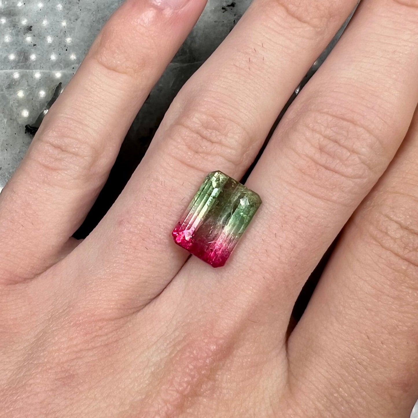A loose pink and green emerald cut watermelon tourmaline gemstone.