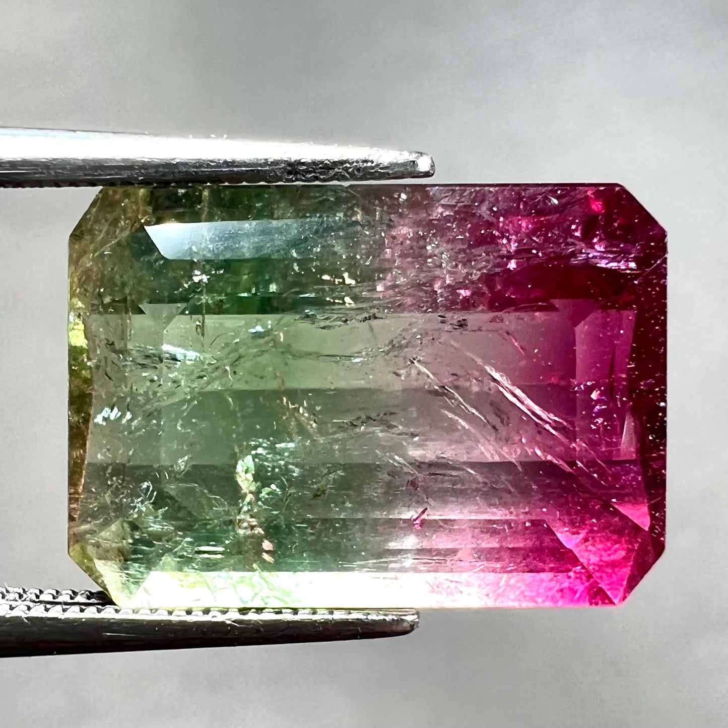 A loose, faceted emerald cut watermelon tourmaline stone.