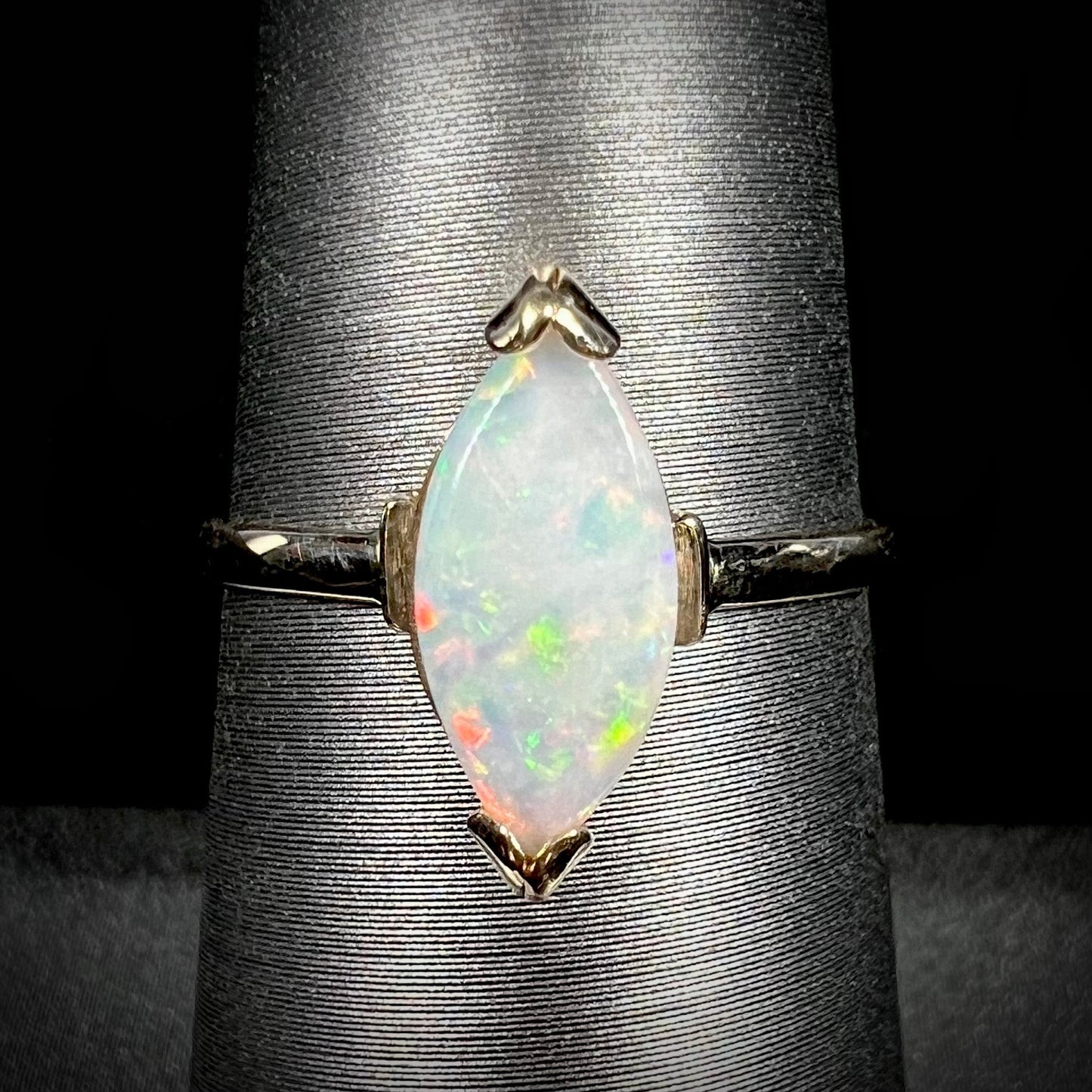 A marquise cut natural opal solitaire ring in yellow gold.