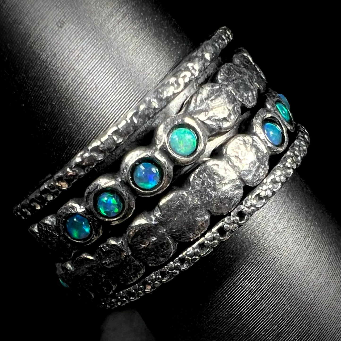 A men's opal spinner band made from sterling silver, shown from the side view.