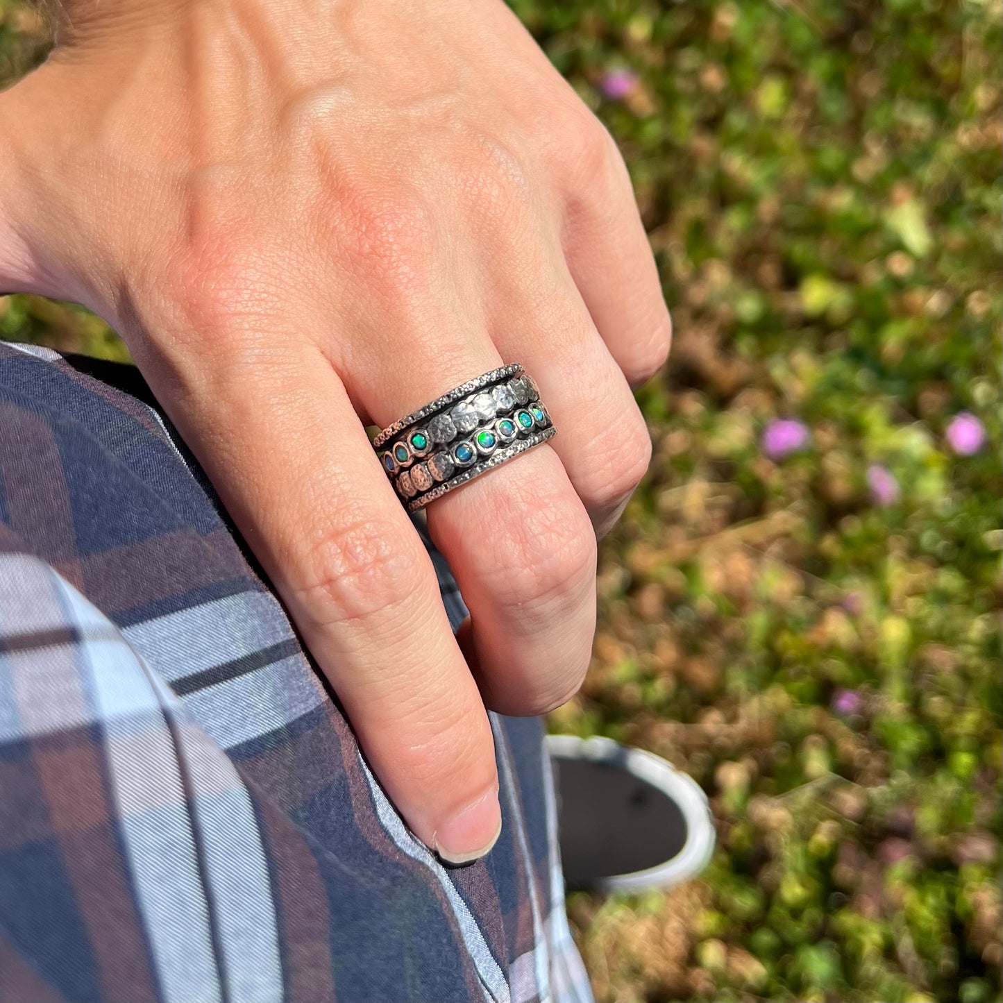 Hand resting on hip while wearing a men's sterling silver opal ring measuring 11.5mm wide.