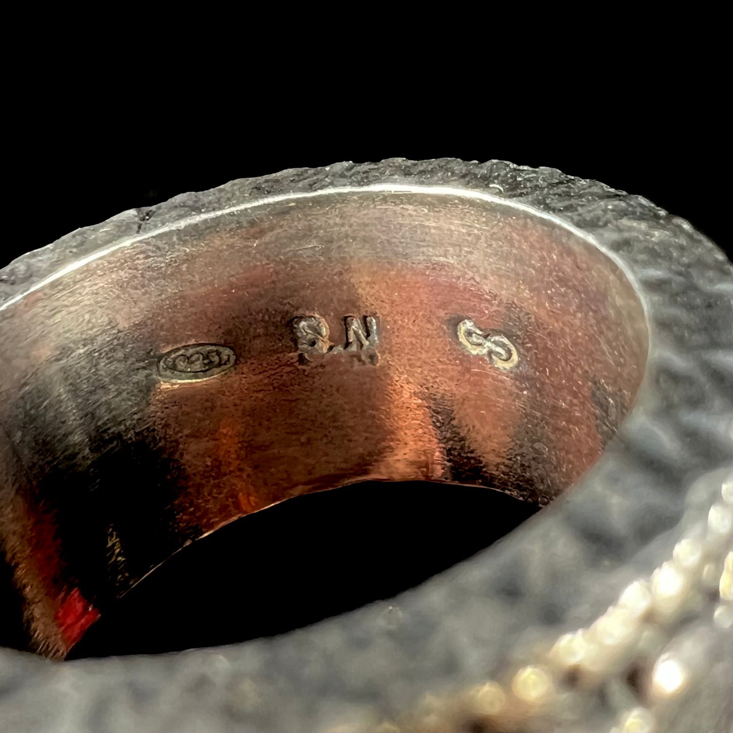 "925" and "S.N." hallmarks shown in an 11.5mm wide men's silver spinner ring.