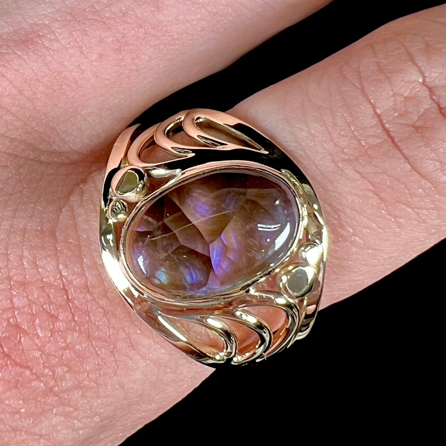 A men's yellow gold fire agate ring. The fire agate is blue and purple with light scratches.