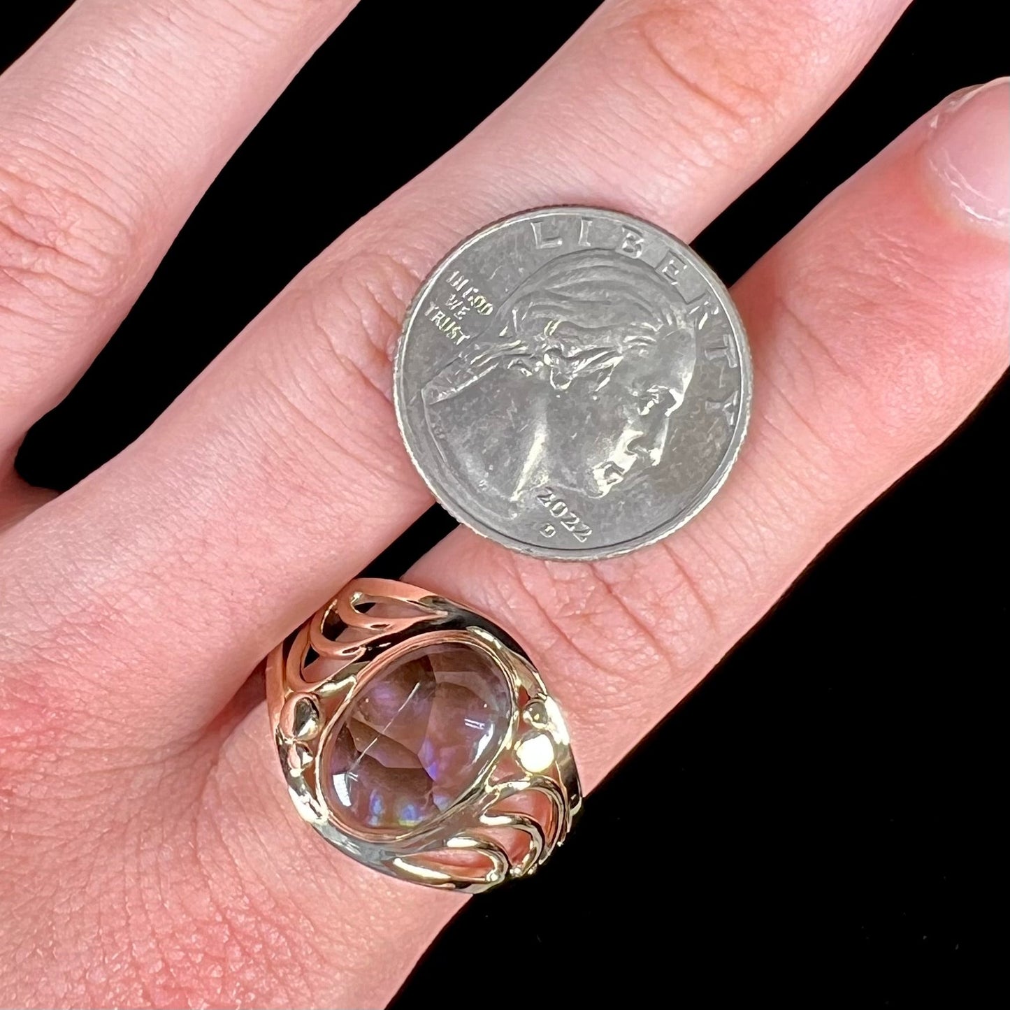 A men's yellow gold fire agate ring. The fire agate is blue and purple with light scratches.