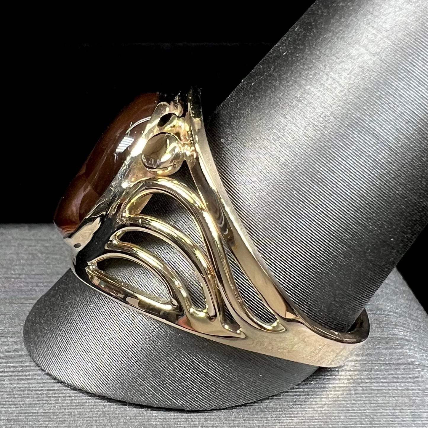 A men's yellow gold fire agate ring. The fire agate is blue and purple with light scratches.