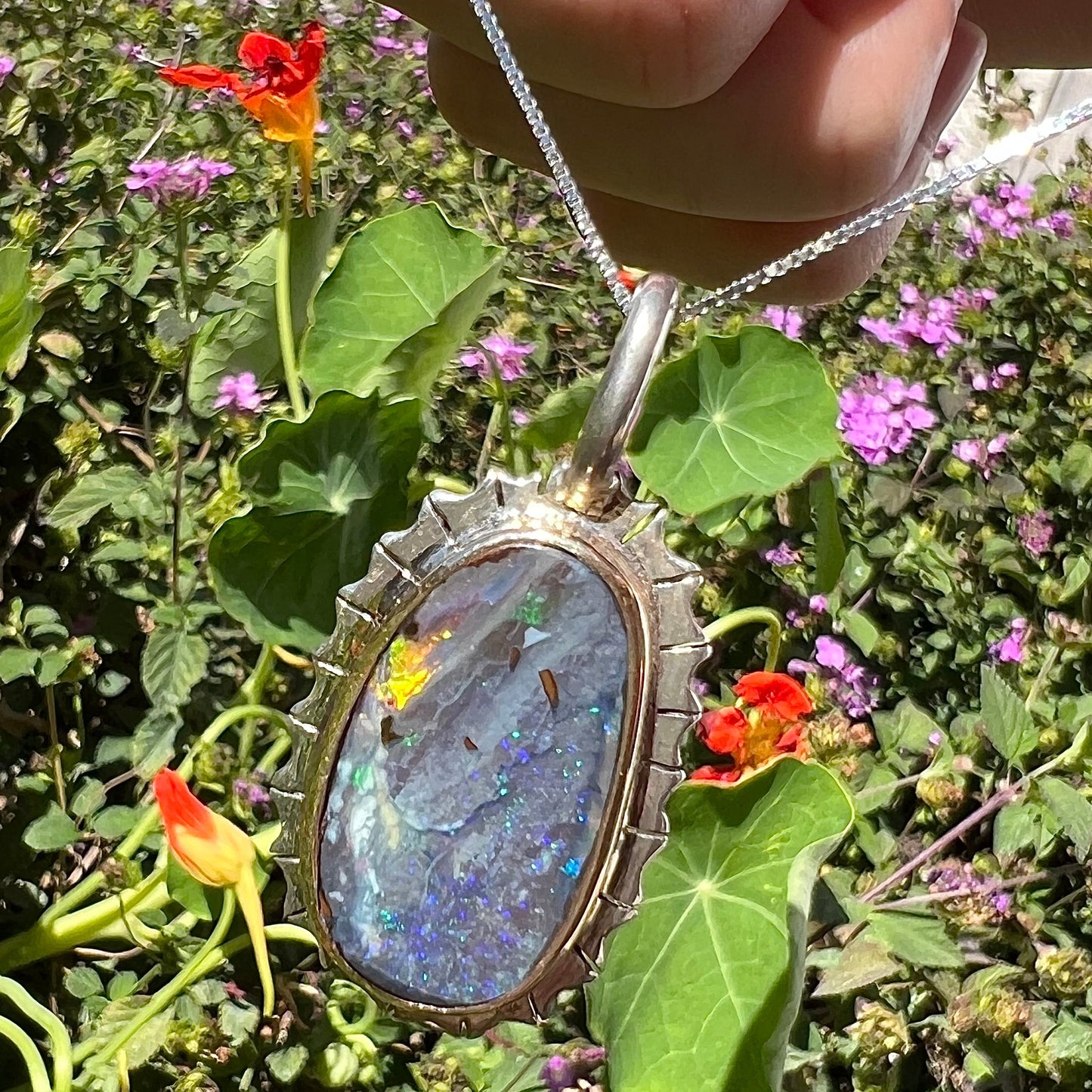 A Southwest style two-tone sterling silver pendant set with a black boulder opal with a yellow gold bezel.
